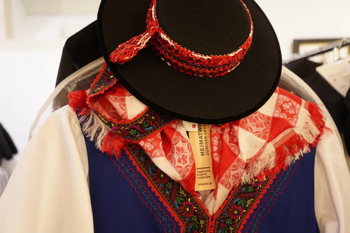 Eine dunkelblaue Tracht mit satten bunten Blumenstickerei.
